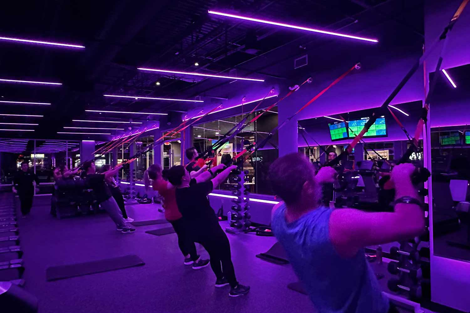 Members exercising in purple light therapy Members exercising in purple light therapy