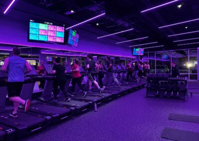 Members exercising in purple light therapy